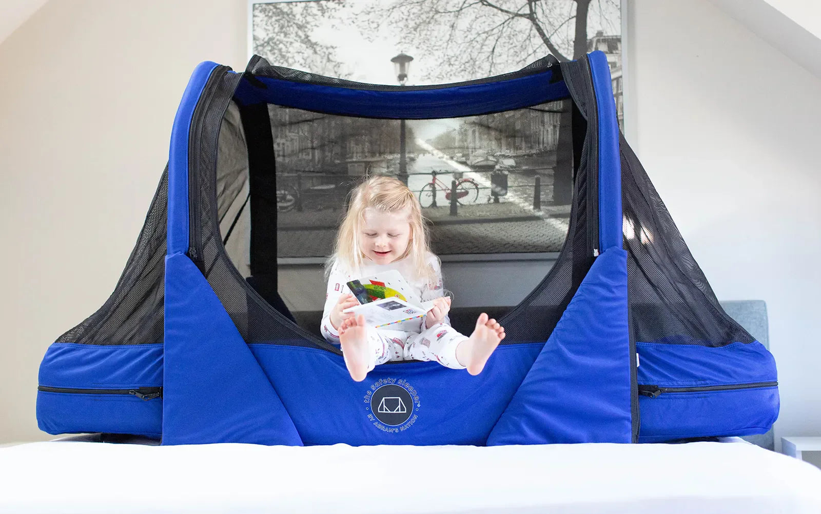 Little girl sitting in a royal blue The Safety Sleeper®